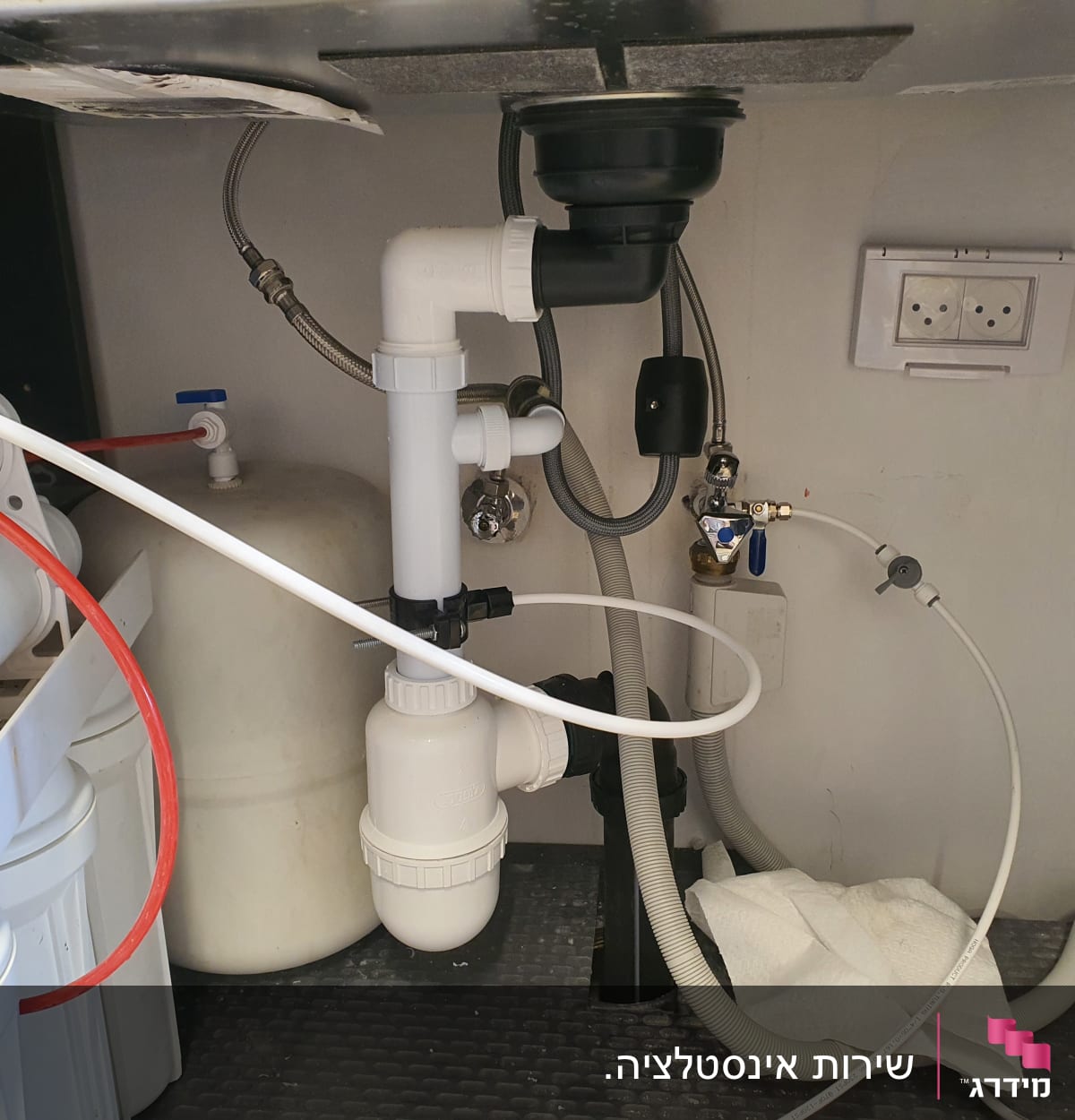 צנרת מתחת לכיור עם מסנן מים וברזים